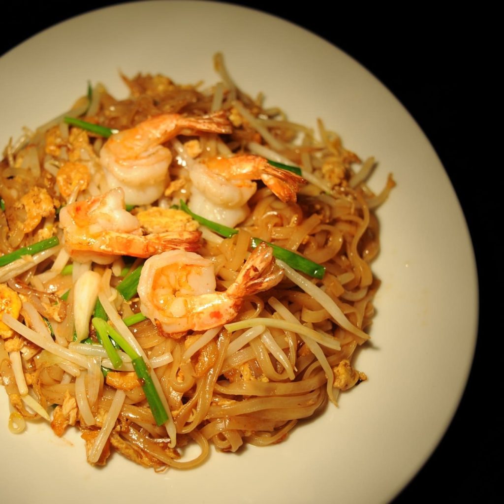 Assiette de pad thaï avec quatre crevettes au dessus